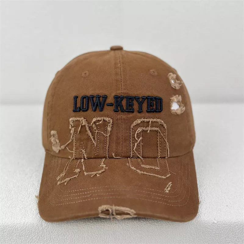 Brown distressed baseball cap with embroidered LOW-KEYED and NO text