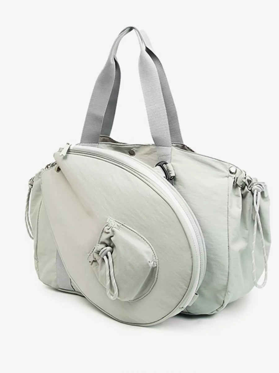 Light gray athletic nylon tote bag with racket holder and cinch-cord details.
