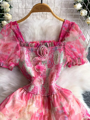 Floral tiered midi dress in pink with smocked bodice and puff sleeves.