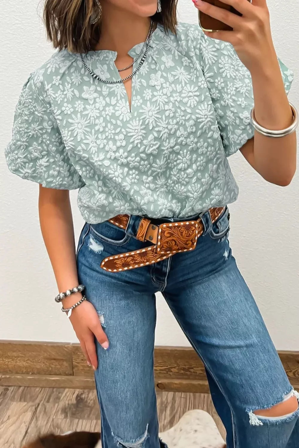 Embroidered puff sleeve floral shirt in light green polyester with a V-neck and textured floral pattern.