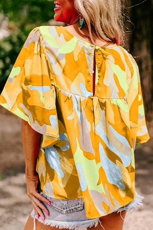 Maternity shirt with abstract print, wide sleeves, and back button closure.