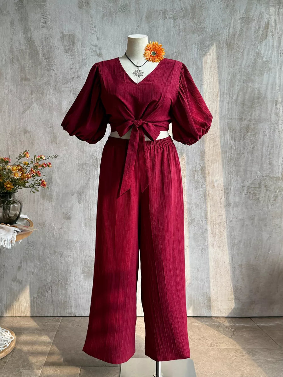 Deep red textured tie-front crop top with balloon sleeves and wide-leg pants set.