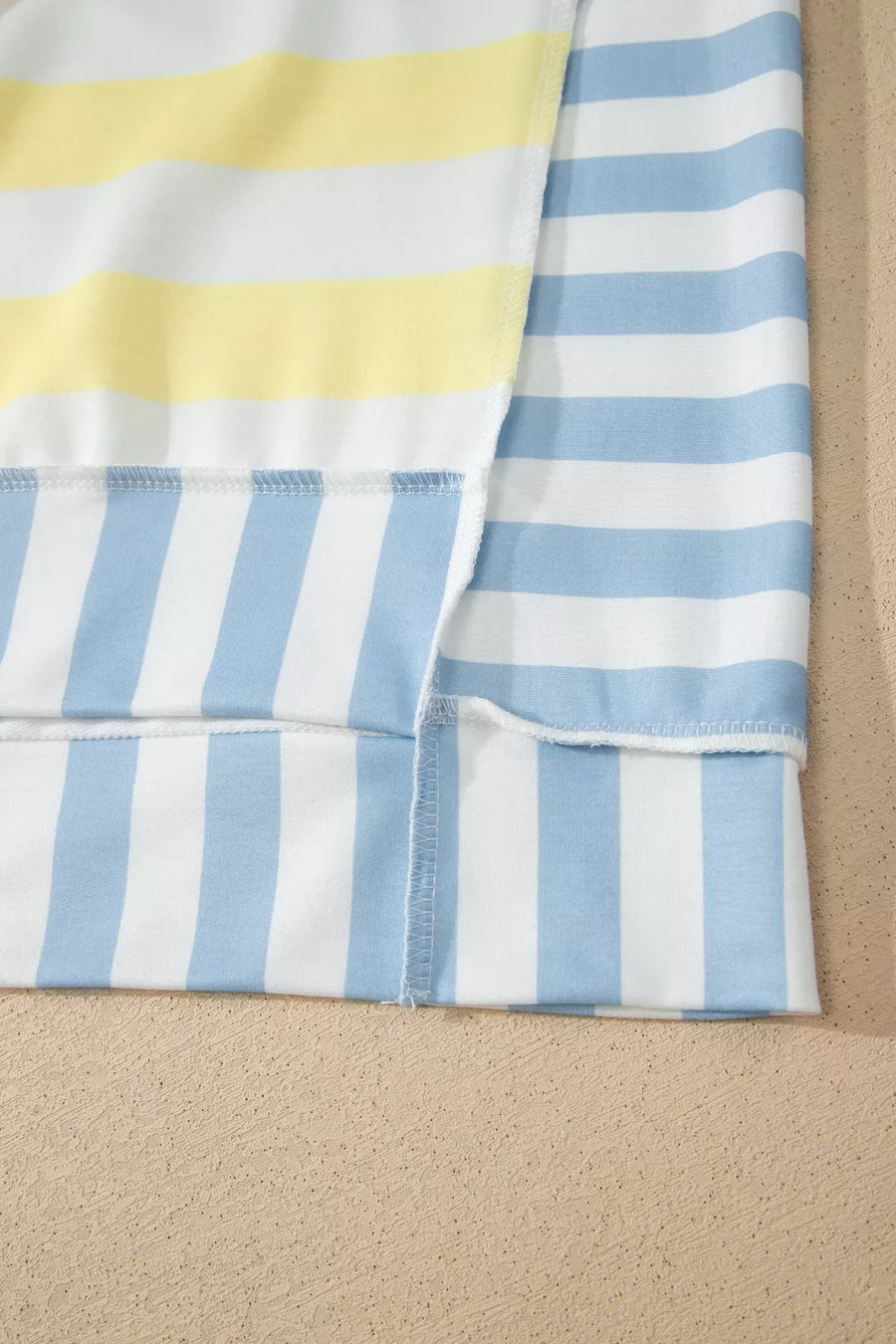 Striped sweatshirt with yellow, white, and blue stripes.
