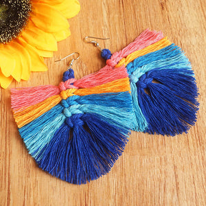 Rainbow fan tassel earrings in pink, orange, light blue, and dark blue with macrame detail.