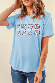 Light blue cotton t-shirt with floral 1776 graphic and relaxed fit.