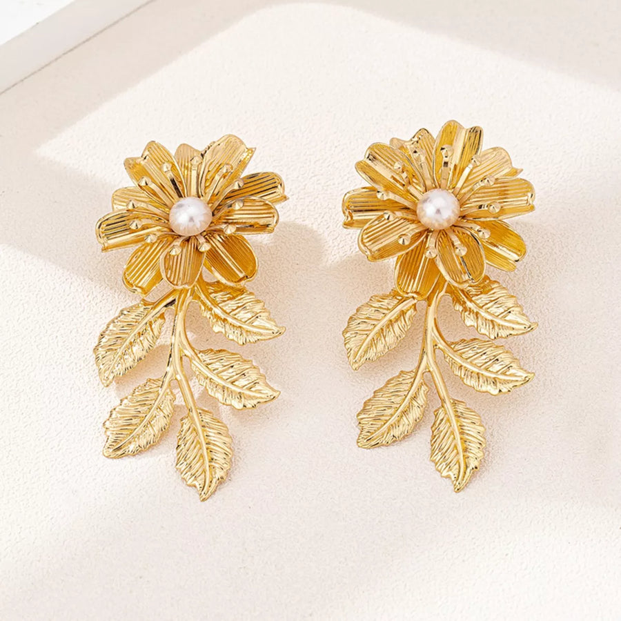Golden floral drop earrings with pearl accents and leaf details.