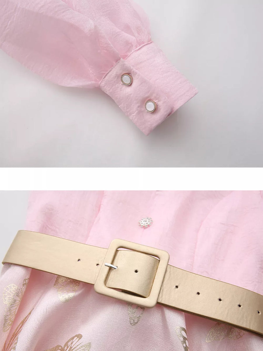 Pink midi dress with butterfly print, cinched waist belt, and button cuffs.