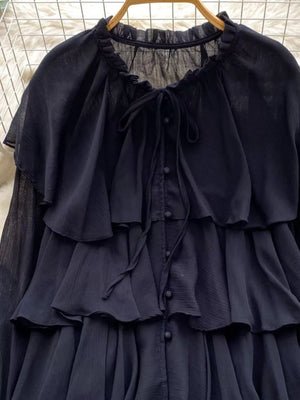 Black chiffon blouse with tiered ruffles, bow tie neck, and button front.