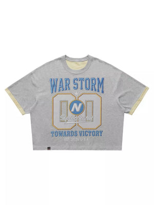 Grey cropped t-shirt with "WAR STORM" graphic and yellow trim.