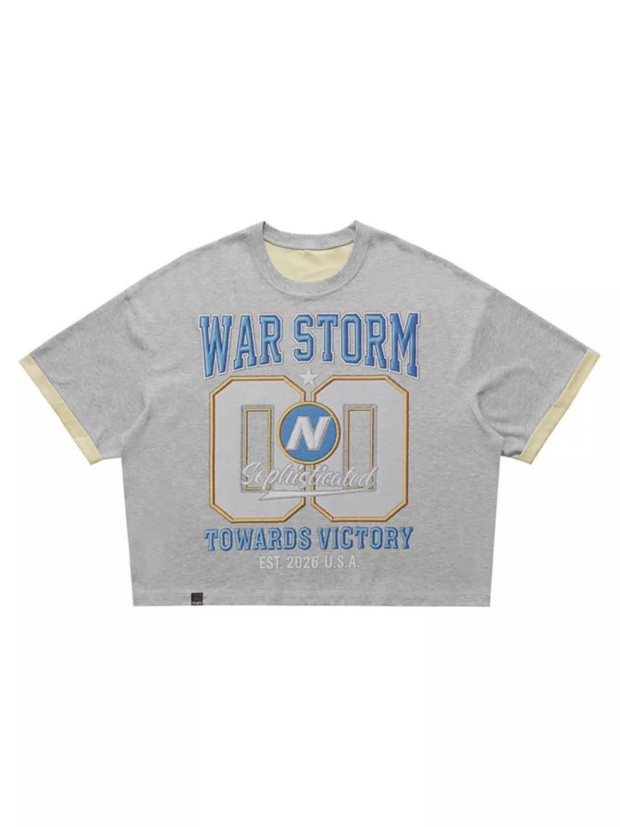 Grey cropped t-shirt with "WAR STORM" graphic and yellow trim.