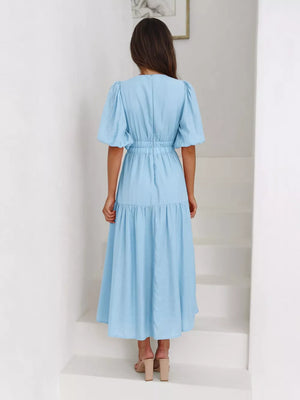 Pastel blue midi dress with puff sleeves, elastic waist, and tiered skirt.