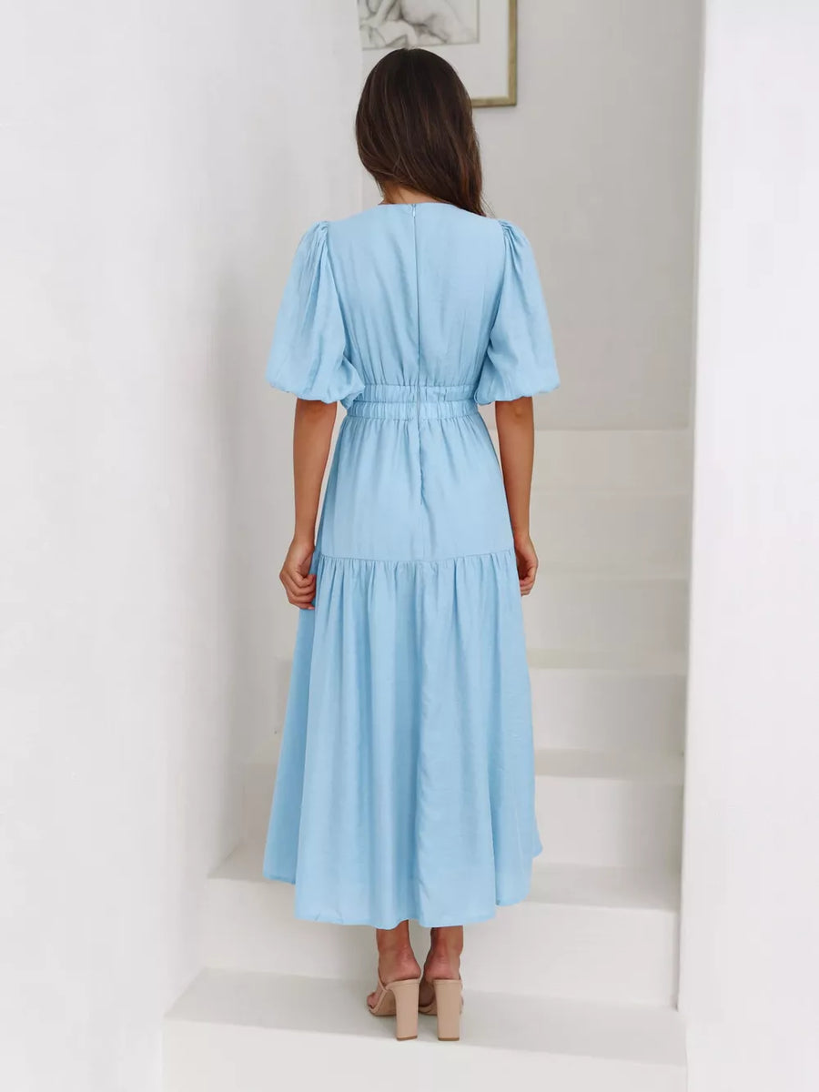 Pastel blue midi dress with puff sleeves, elastic waist, and tiered skirt.