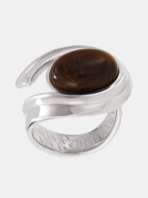 Silver ring with a sculptural swirl design and a brown tiger's eye stone.