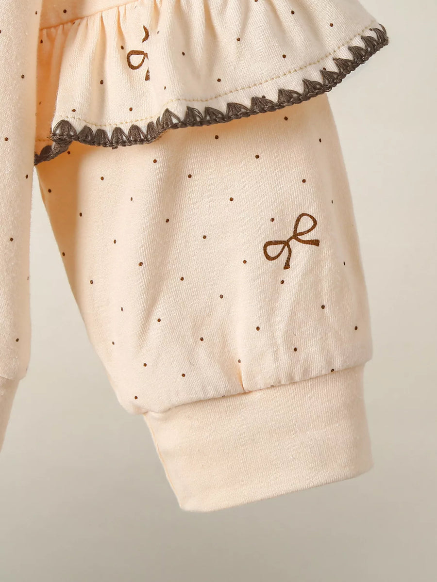 Tan polka dot baby outfit with ruffle trim and embroidered bow detail.