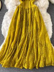 Yellow lace maxi dress with ruffled neckline and flowing skirt.