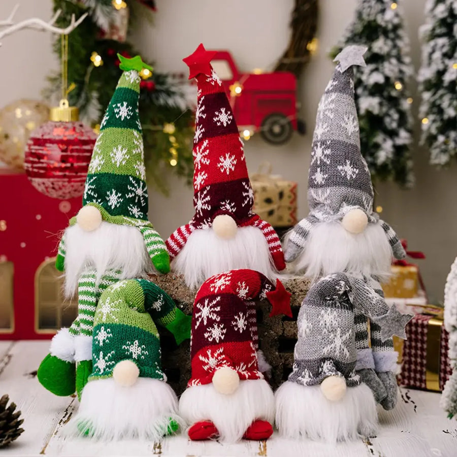 Illuminated knit gnomes in red, dark gray, and dark green with snowflake patterns.