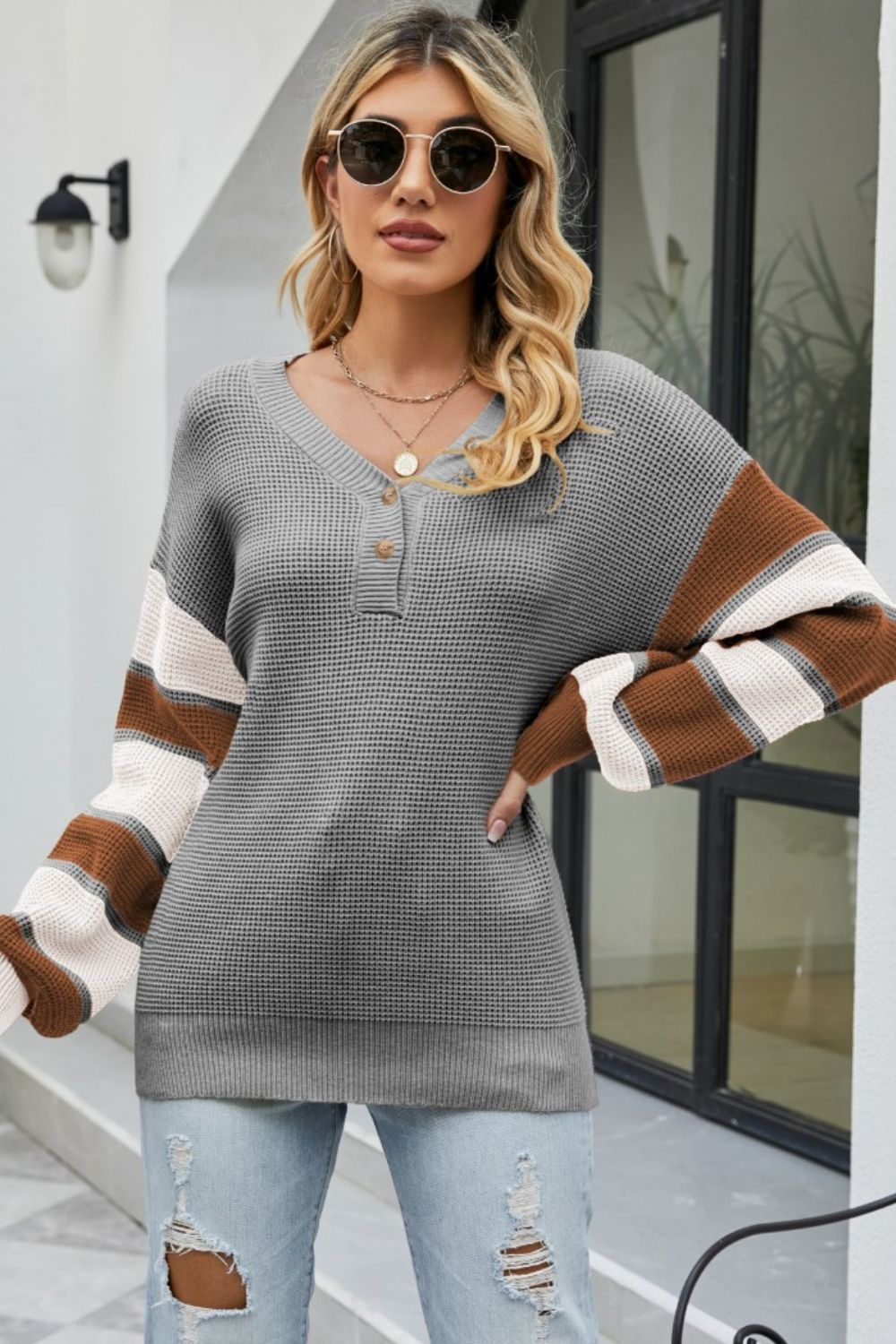 Waffle knit henley sweater in grey with striped sleeves and button neck detail.