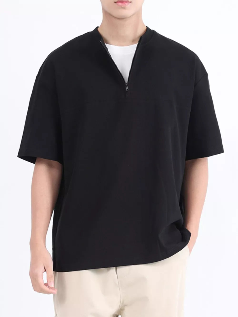 Black cotton half-zip t-shirt with short sleeves and a relaxed fit.