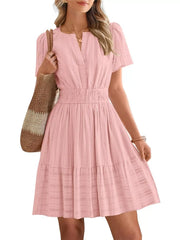 Pink textured V-neck tiered dress with smocked waist and short sleeves.