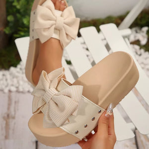 White ribbed bow accent platform sandals with stud details.