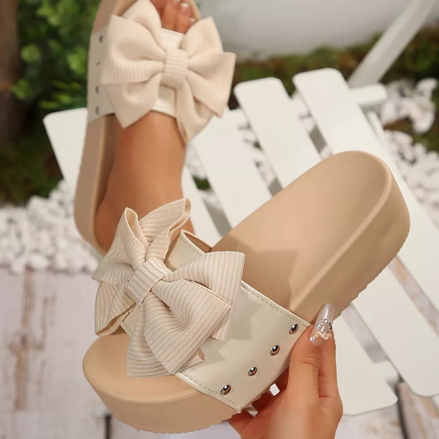 White ribbed bow accent platform sandals with stud details.