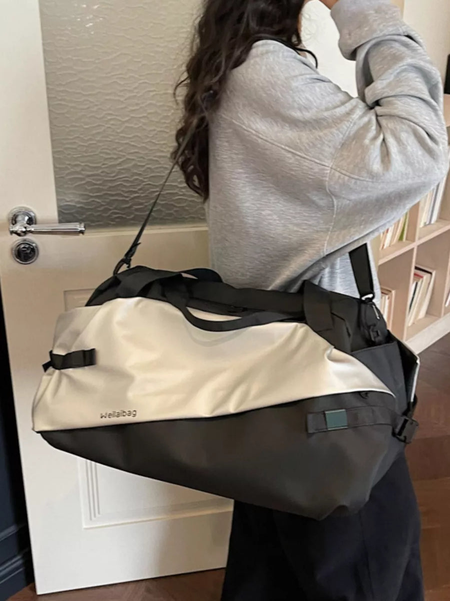 Oxford cloth travel bag in black and silver with dual handles and shoulder strap.