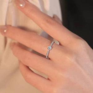 Elegant moissanite ring in sterling silver with a brilliant center stone and pave band.