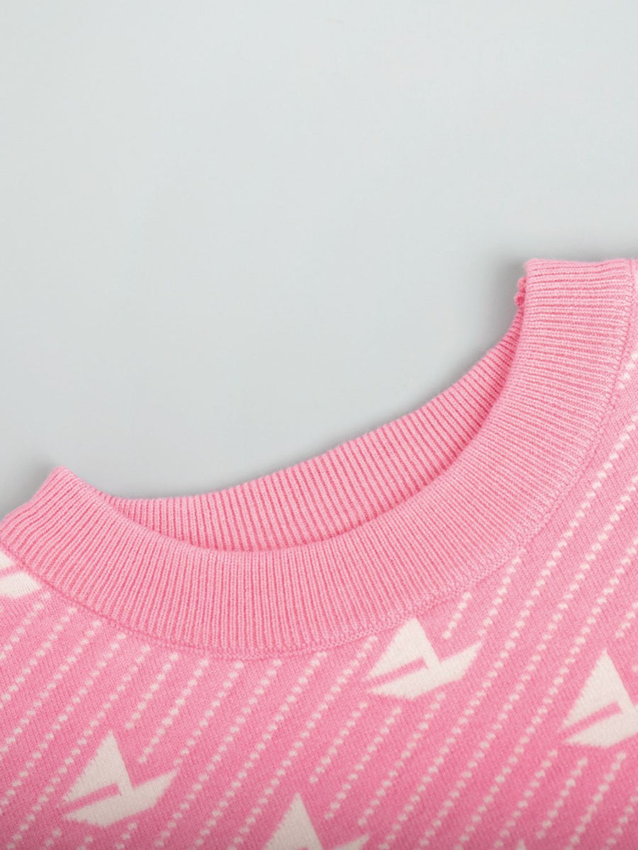 Blush pink knit sweater with sailboat jacquard pattern and ribbed crewneck.