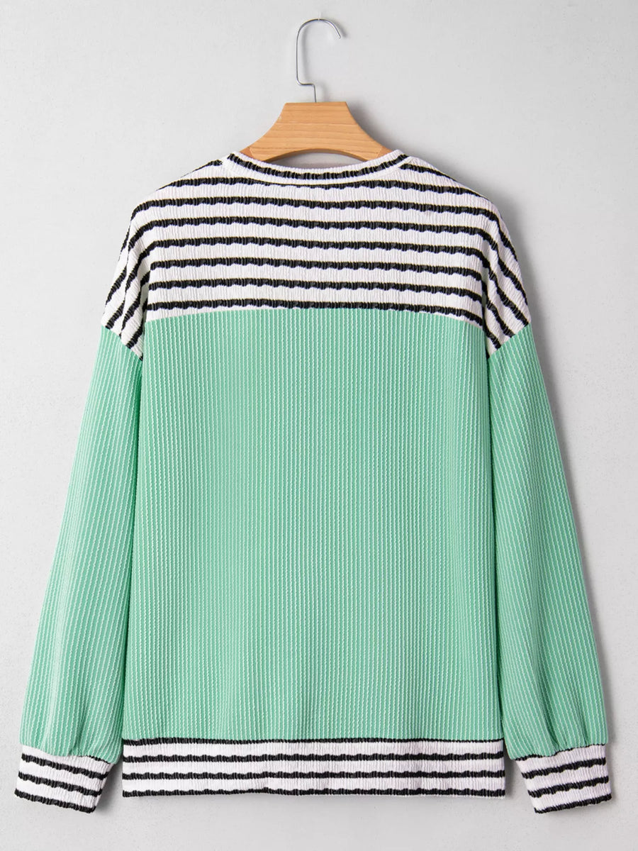 Turquoise long-sleeve top with horizontal stripes on the yoke and cuffs, and a ribbed texture.
