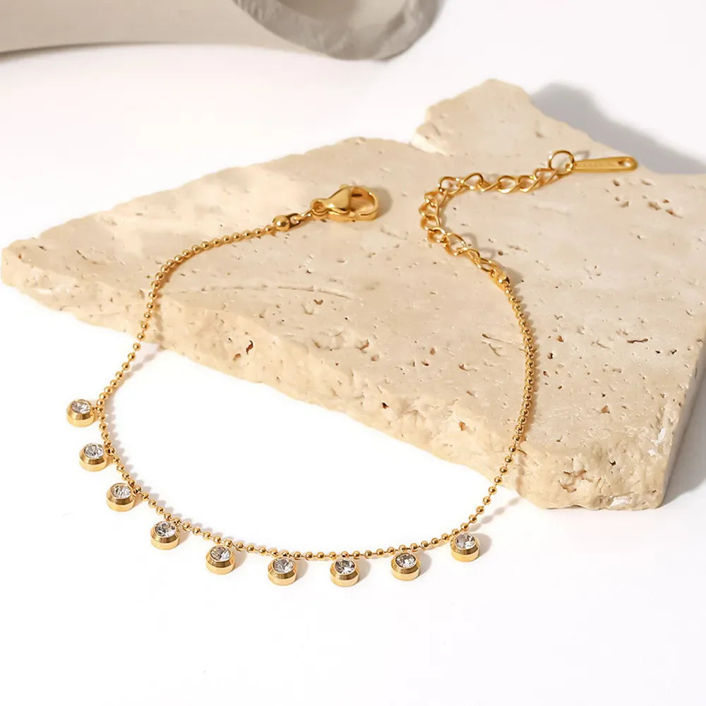 Gold-plated necklace with delicate dangling pavé charms and a beaded chain.