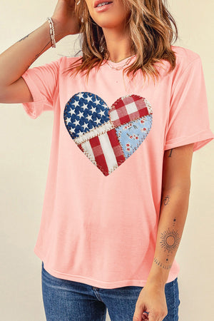 Pink t-shirt with a patriotic heart graphic made of patchwork American flag, gingham, and floral fabric.