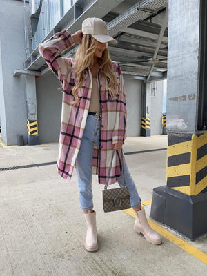 Long plaid shirt jacket in pink and white with a collar and button front, styled with jeans.