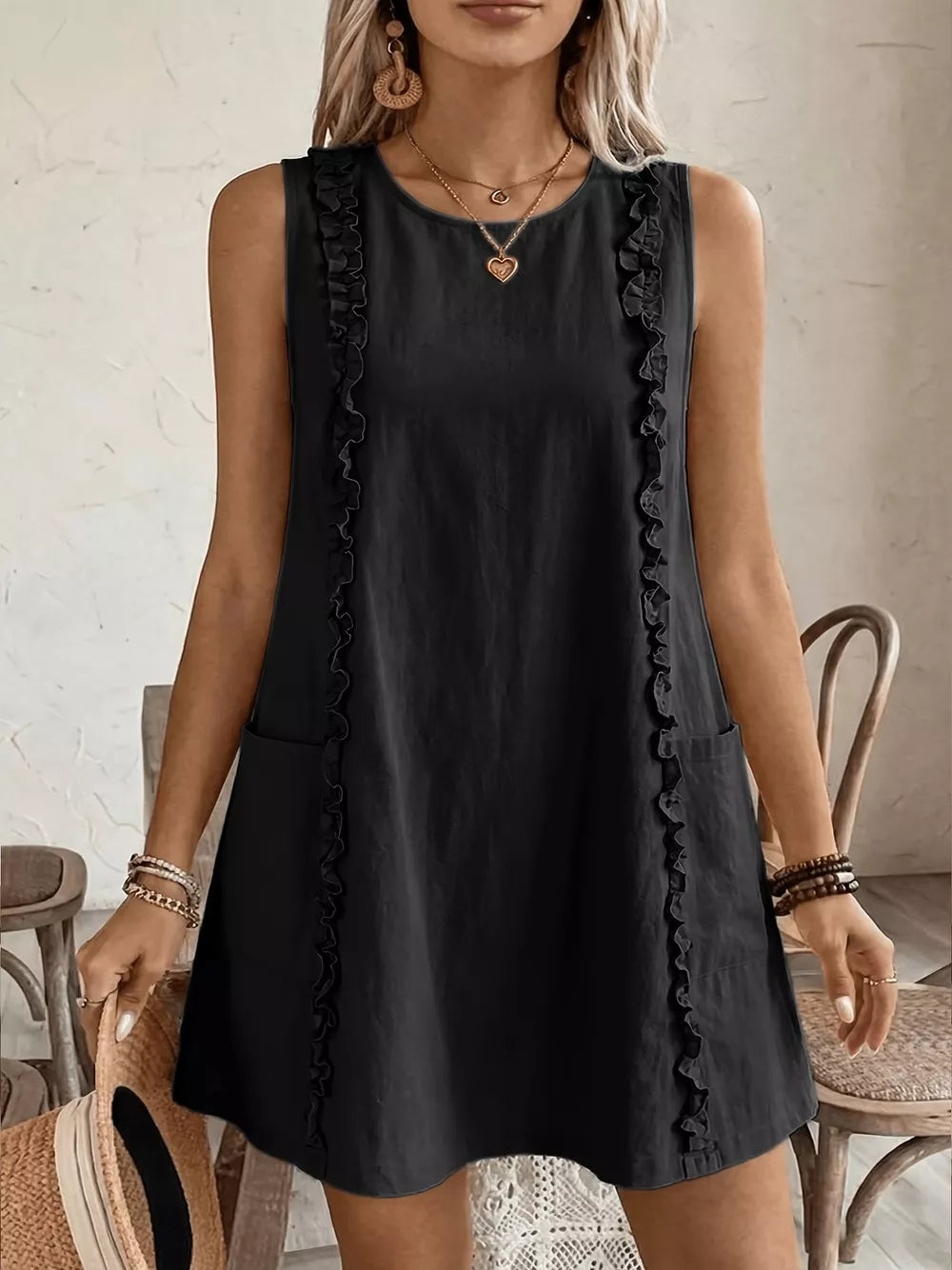 Black sleeveless dress with frill trim and pockets, crew neck, A-line cut.