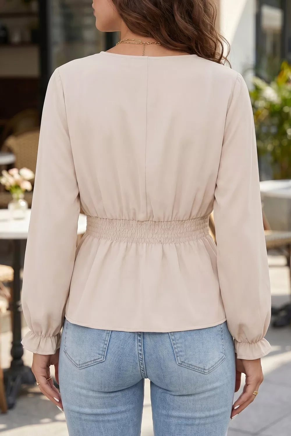 Elegant V-neck blouse in beige polyester with smocked waist and ruffled cuffs.