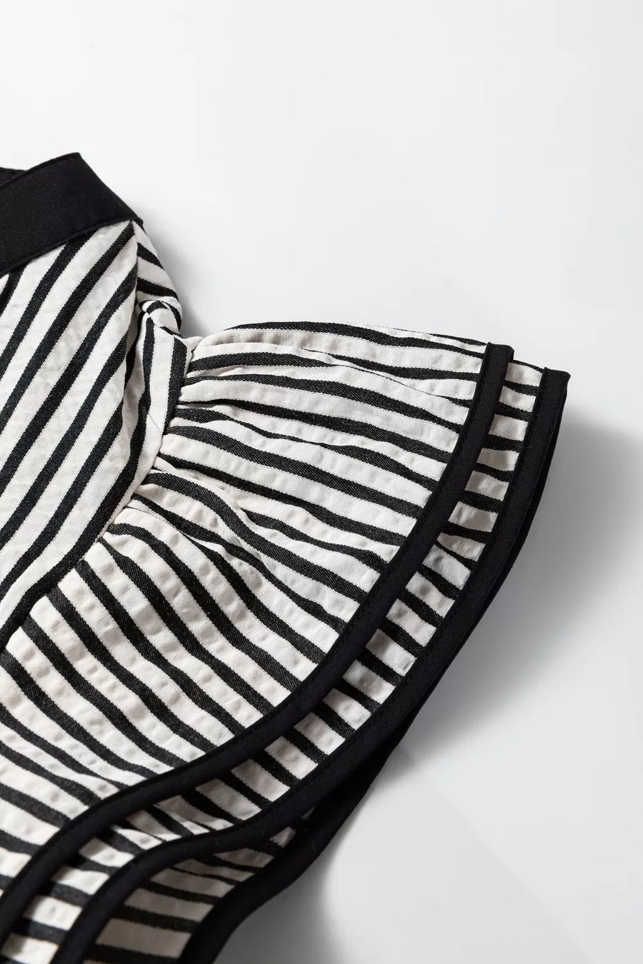 Chic black and white striped cotton midi dress detail with ruffled sleeves and black trim.