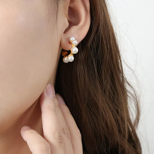 Sculpted pearl and gold hoop earrings with a casual, modern design.