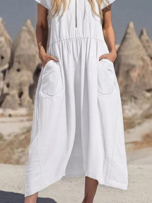 White midi dress with zip neckline, elastic waist, and large functional pockets.