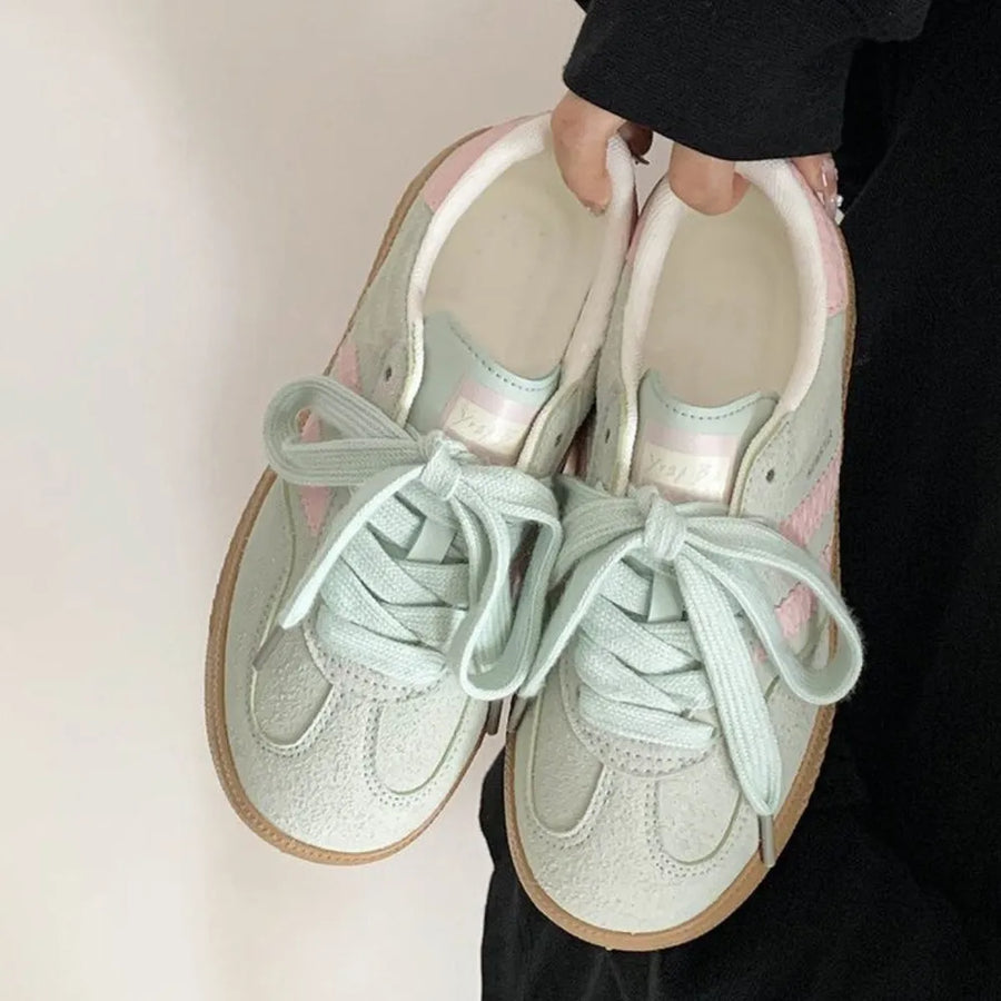 Pastel blue suede trainers with pink signature stripes and light blue laces.