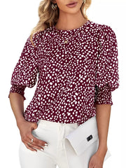 Burgundy animal print blouse with half sleeves and ruched cuffs.