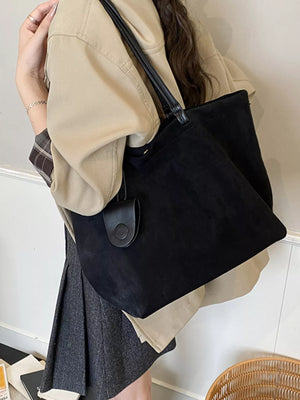 Large black suede tote bag with leather straps and a small attached pouch.