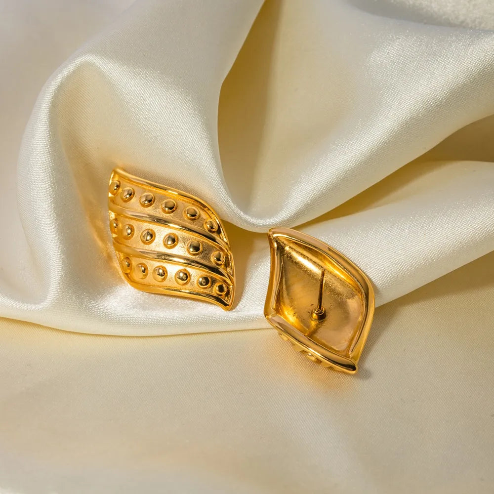 Sculpted gold leaf stud earrings with raised dot detail, 18K gold-plated.