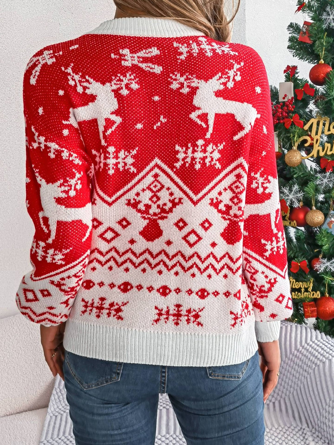 Red acrylic knit sweater with geometric reindeer and snowflake Fair Isle pattern.
