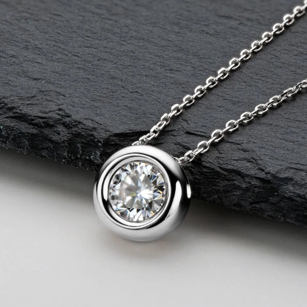 Silver solitaire pendant necklace with bezel-set clear stone on a delicate chain.