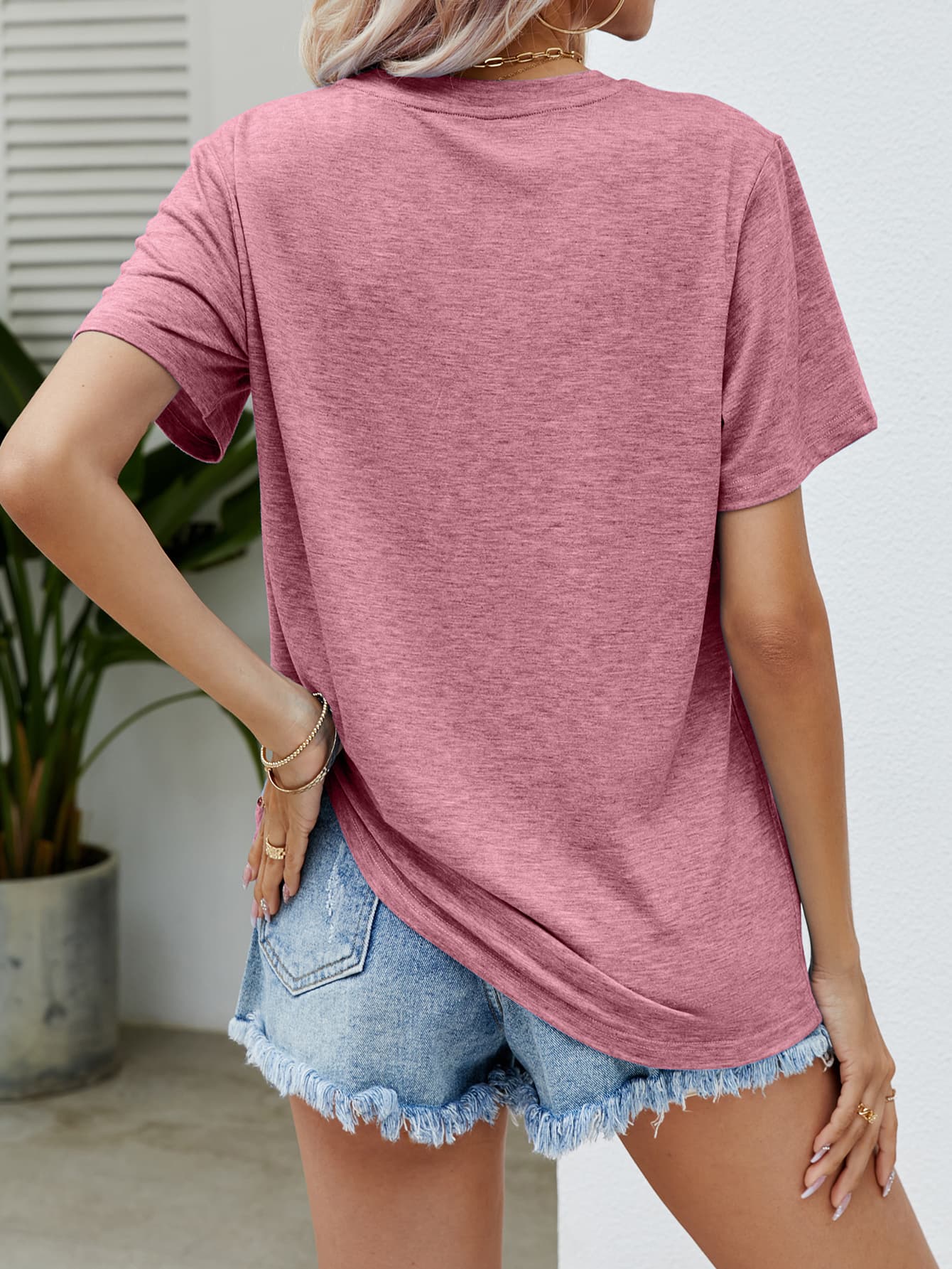 Blush Pink graphic tee with short sleeves and a crew neck, styled with denim shorts.