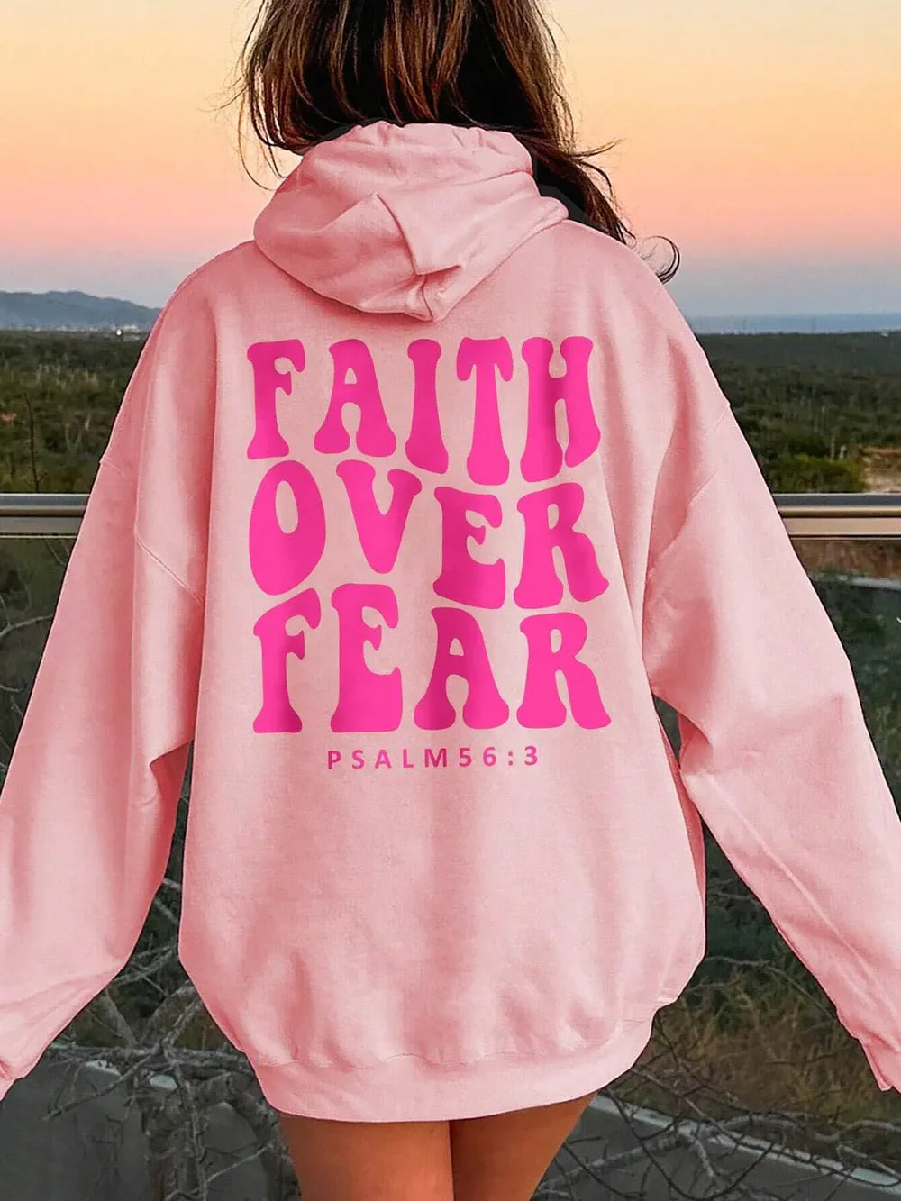 Pink graphic hoodie with "FAITH OVER FEAR" and "PSALM 56:3" text on back.