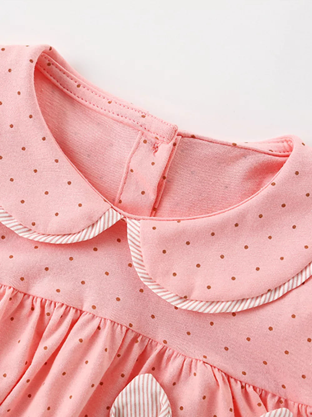 Pink polka dot cotton baby dress with Peter Pan collar and striped trim.