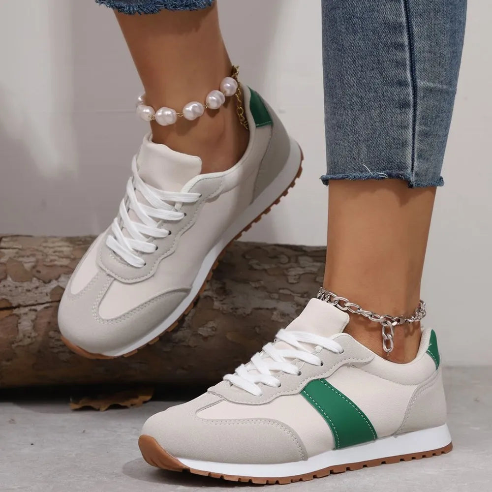 Beige suede and canvas sneakers with green accents and white laces.