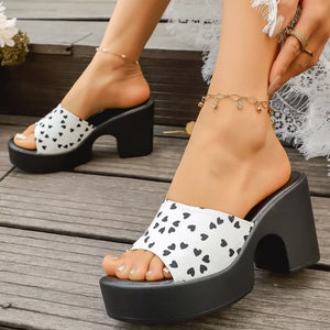 White and black heart print block heel platform sandals with open toe.