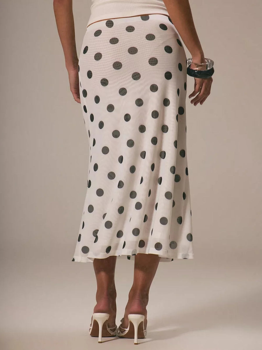 Classic polka dot midi skirt in white with black dots, featuring a flowy silhouette and sheer fabric.