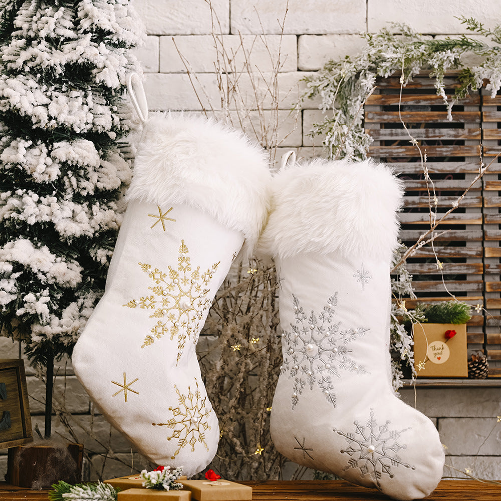 White Christmas stockings with embroidered gold and silver snowflakes and faux fur trim.